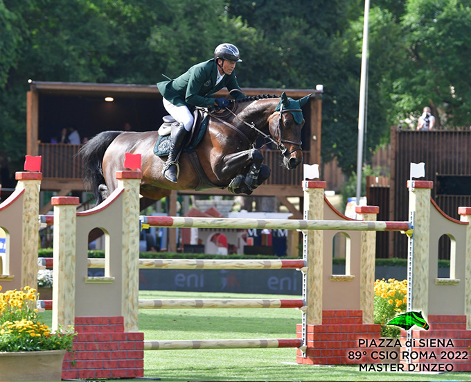 Francesco Turturiello sospeso sul salto dell'oxer in sella al cavallo baio Made In