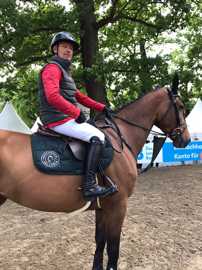 il cavaliere svizzero è in sella al suo cavallo mentre tiene in mano le redini